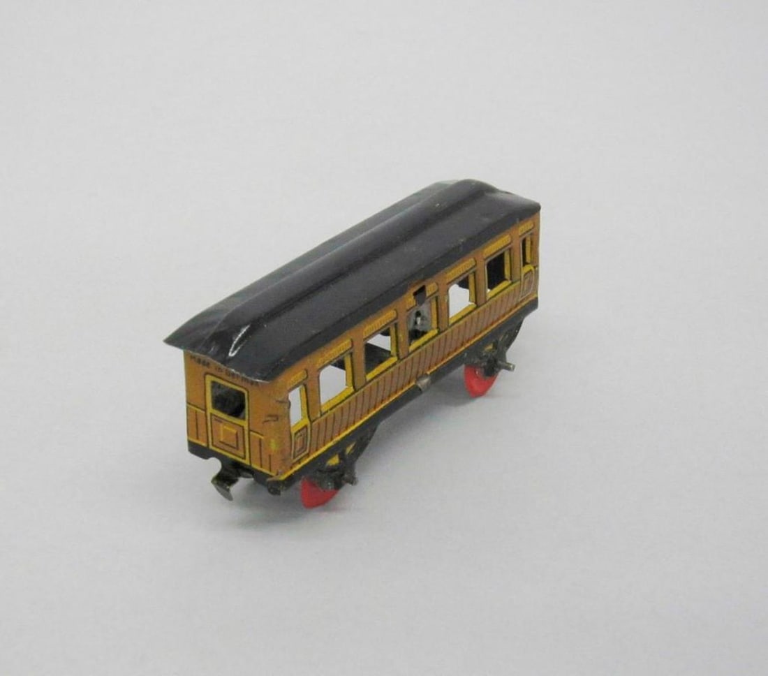 Huki Passenger Train Coach car: Toy passenger coach car; light brown exterior with black roof; red wheels; "Made in Germany" printed on front and rear ends. Dimensions: 1 1/2 x 3/4 x 3 1/2 inches (3.8 x 1.9 x 8.9 cm). Condition: Loo