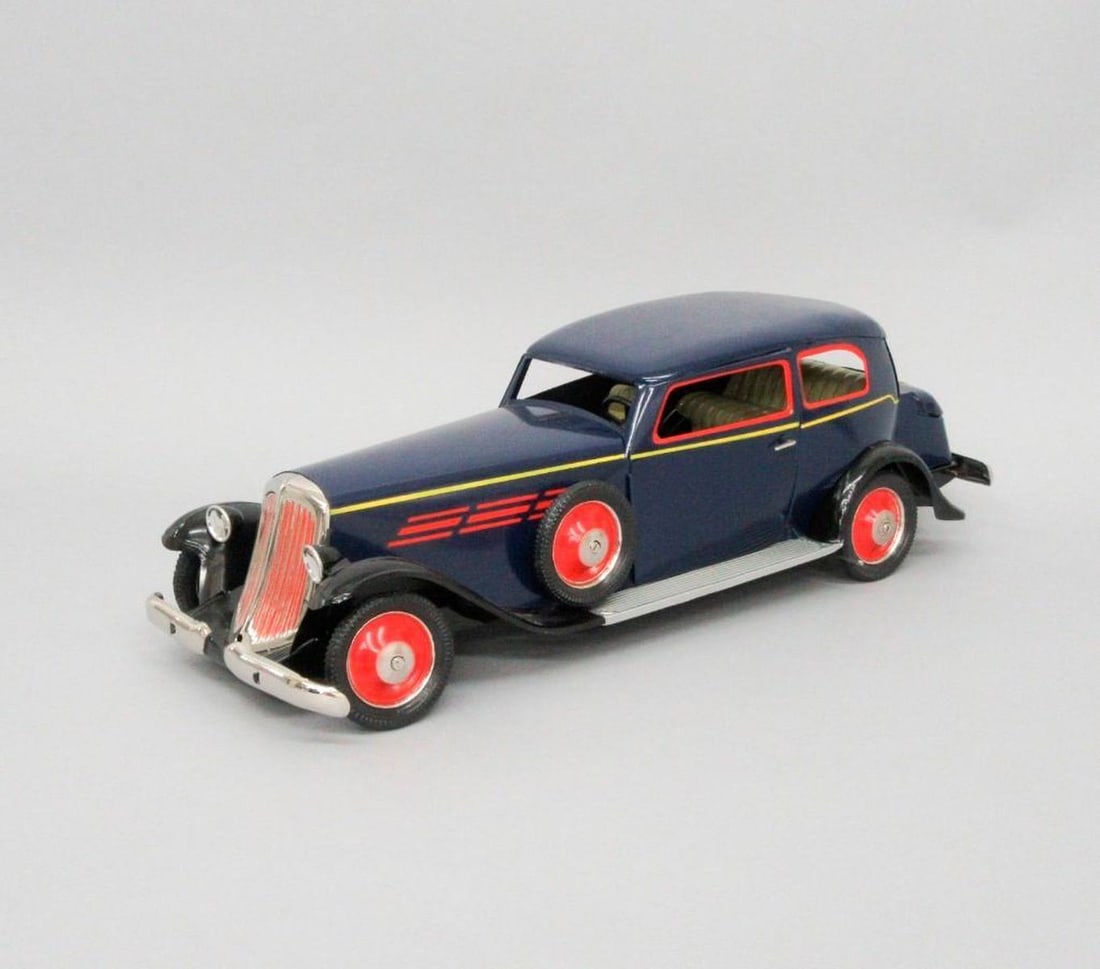 Schuco, Spuelwarenwerke Schreuer & Co., blue sedan car: A dark blue toy car with red and yellow accents; red hub caps; wind-up key in separate bag. en suite with retail box. Dimensions: 5.5" x 5.5" x 18.75" (14 x 14 x 47.6 cm). Overall good condition. Both