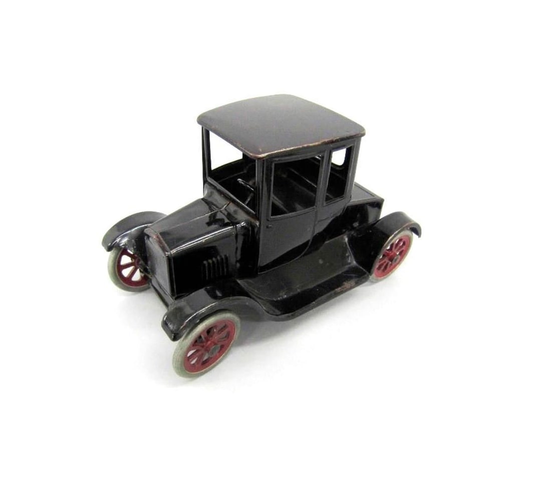 Moline Pressed Steel Co Buddy "L" Flivver Car: Circa 1925, a black toy car with red and white wheels and decal maker's label on underside. Dimensions: 6.5" x 5" x 11" (16.5 x 12.7 x 27.9 cm). Condition: Wheels are worn and loose. Surface scratches
