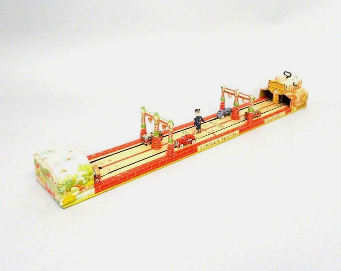 Unique Art Manufacturing Co Litho Tin Model of Lincoln Tunnel: Circa 1935, lithographed tinplate toy model of Lincoln Tunnel with clockwork mechanism and moving buses and car. Dimensions: 3" x 24" x 3.5" inches (7.6 x 61 x 8.9 cm). Condition: Scratches as well de