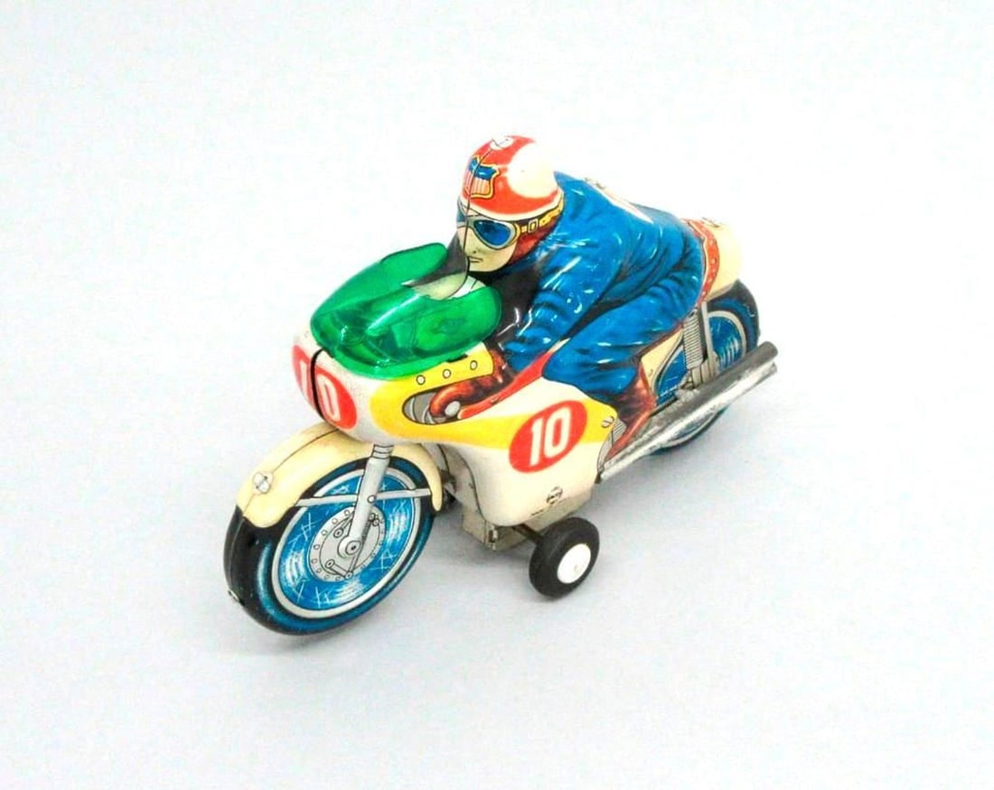 Japanese Tinplate Motorcycle and Driver: Tinplate motorcycle toy with rider, plastic windshield, and "10" printed on sides of fuel tank; "Moto" and "Made in Japan" printed on proper left side near bottom. Dimensions: 4.25" x 2" x 6" (10.8 x