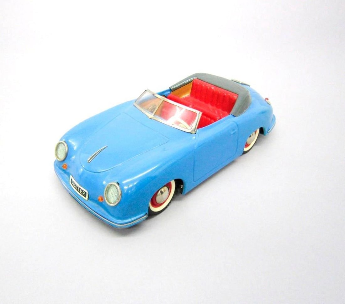 Distler Electro Matic 7500 Porsche 356A: Circa 1952-1963, battery-operated tinplate Porsche with red seats, removable key on leather strip, and Distler makers mark. Dimensions: 3.25" x 4" x 9.75" (8.3 x 10.2 x 24.8 cm). Condition: Scattered