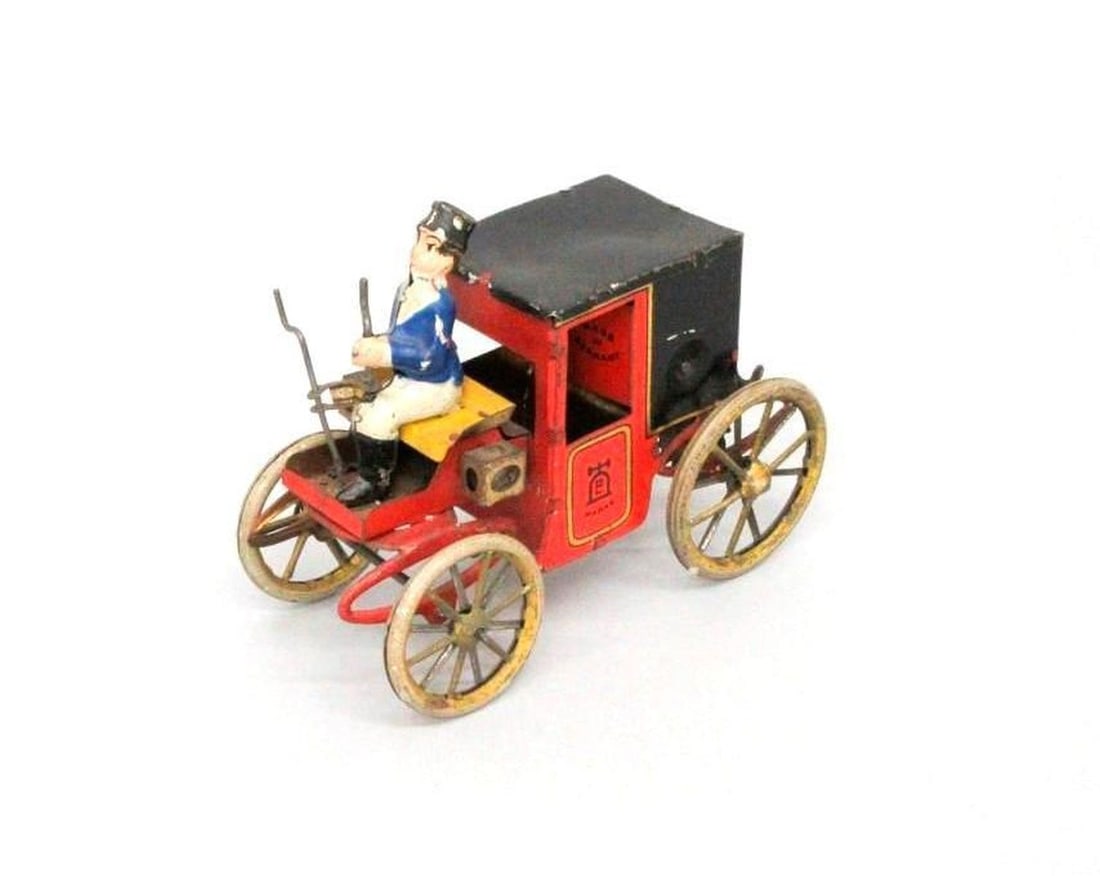 German Mechanical Wagon with Driver: The red and black mechanical clockwork wagon with gold wheels and a driver dressed in blue jacket with white pants; unidentifiable manufacturer's mark printed on sides; "Made in Germany" printed on in