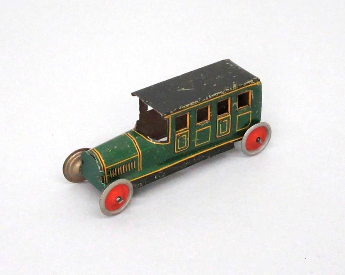Fischer Penny Limousine Car: The small toy penny limousine car having a dark green exterior with yellow trim and black roof; bright red hubcaps painted on wheels. Dimensions: 1" x .75" x 2.75" (2.5 x 1.9 x 7 cm). Condition: Scrat