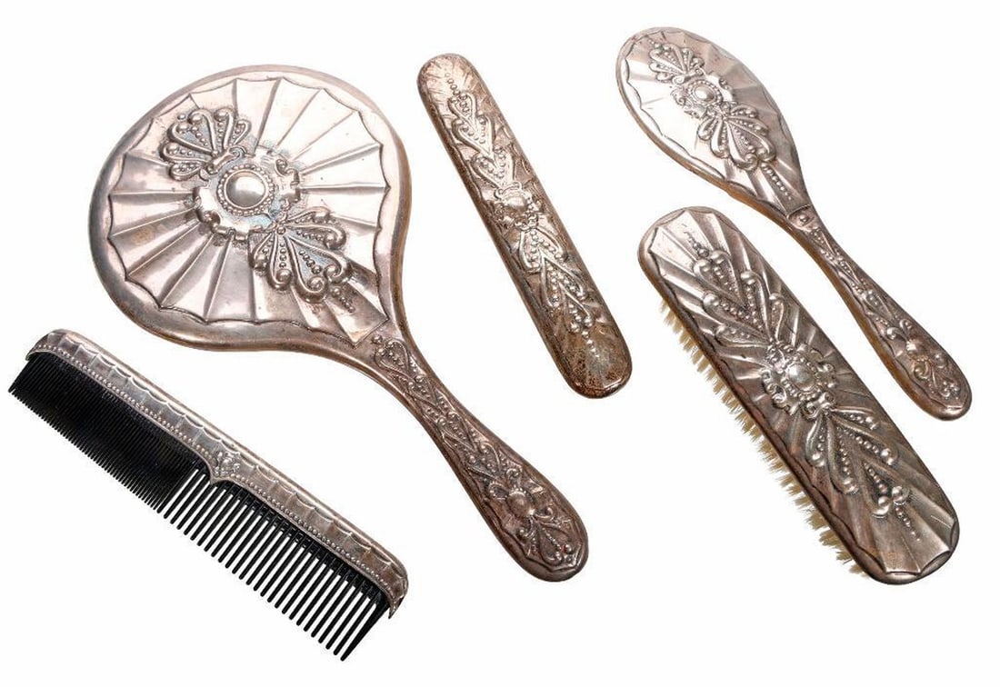 Continental Art Nouveau Silver Dresser Set: Comprising a hand mirror 11.25"l {mirror loose}; a brush mount 9.5"l {lacking brush} (2) clothes brushes, the larger 6.75"l {the smaller separated from brush}; a silver mounted comb; together with a f