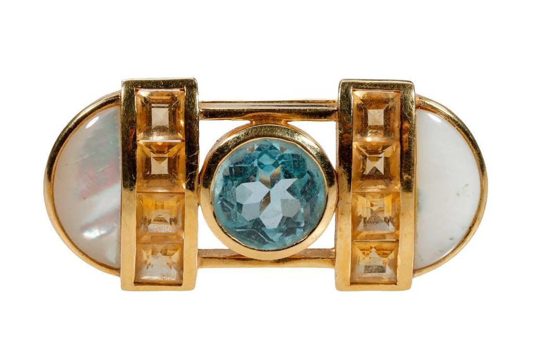A blue topaz, citrine, mother-of-pearl and 18k gold brooch: centering a round blue topaz weighing approximately 2.65 carats, flanked by rows of channel-set square-cut citrines and half-moon mother-of-pearl carvings; weighing approximately 9.2 grams; length: 1 