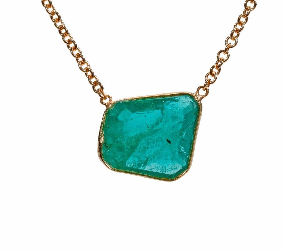 An emerald and 18k gold necklace: featuring a bezel-set trapezoid-shaped emerald weighing 2.55 carats, to a fine link chain; weighing approximately 2.9 grams; length: 17 1/2 in.