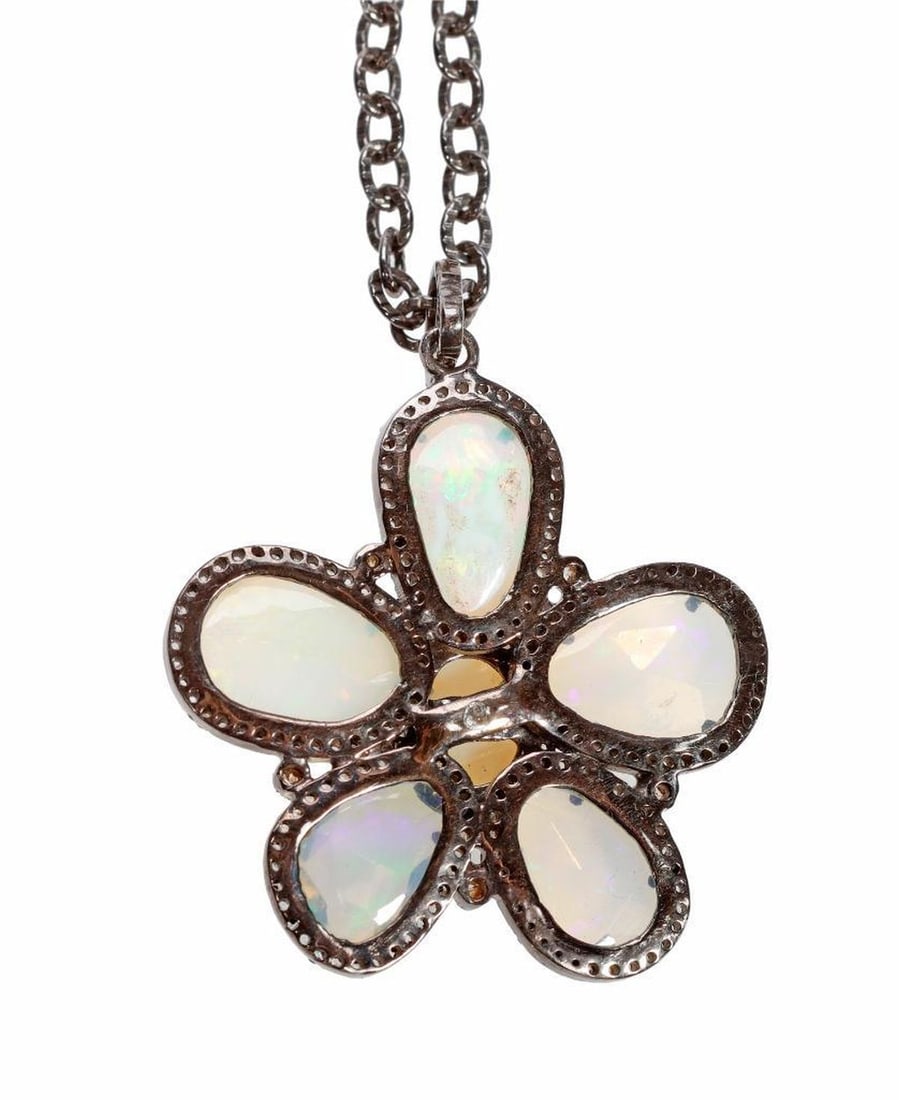 An opal, diamond and blackened silver pendant-necklace: of flower motif, the pendant designed with six faceted opals weighing in total 8.40 carats, framed with numerous round brilliant-cut diamonds; total diamond weight: 1.20 carats; weighing approximately