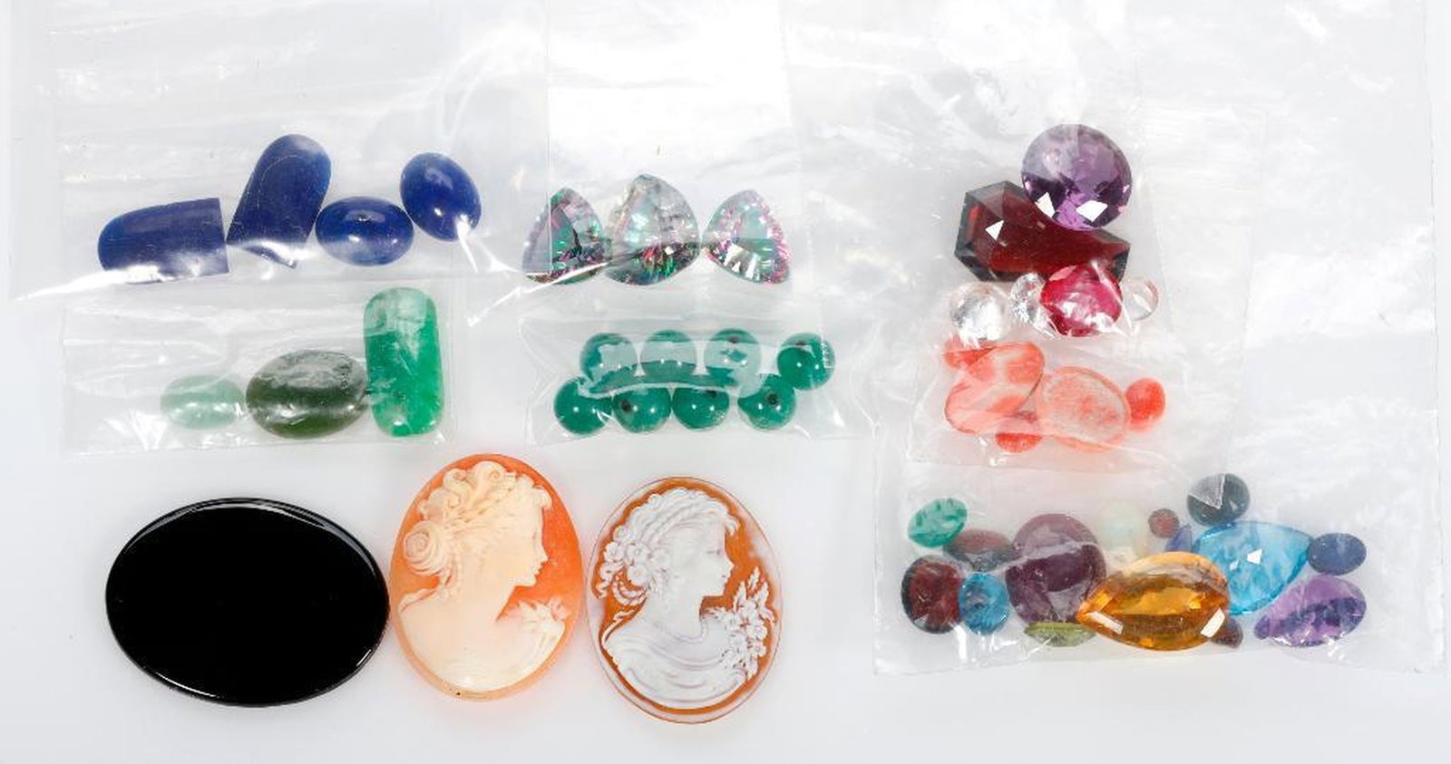 Collection of unmounted stones: including shell cameos, Mystic quartz, jade, coral, cubic zirconia, lapis, onyx, aventurine, citrine, topaz, amethyst, peridot, composite ruby, opal and emerald; estimated total weight: 290 carats