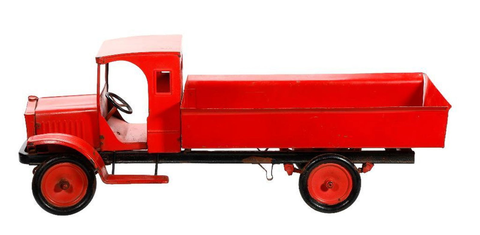 Deco Steel Dump Truck: Circa 1920s. The red pressed steel cab and dump bed on black chassis with red hub caps to the wheels, step into cab has impressed lettering which is hard to read, 9"h x 28.25"l x 10"d