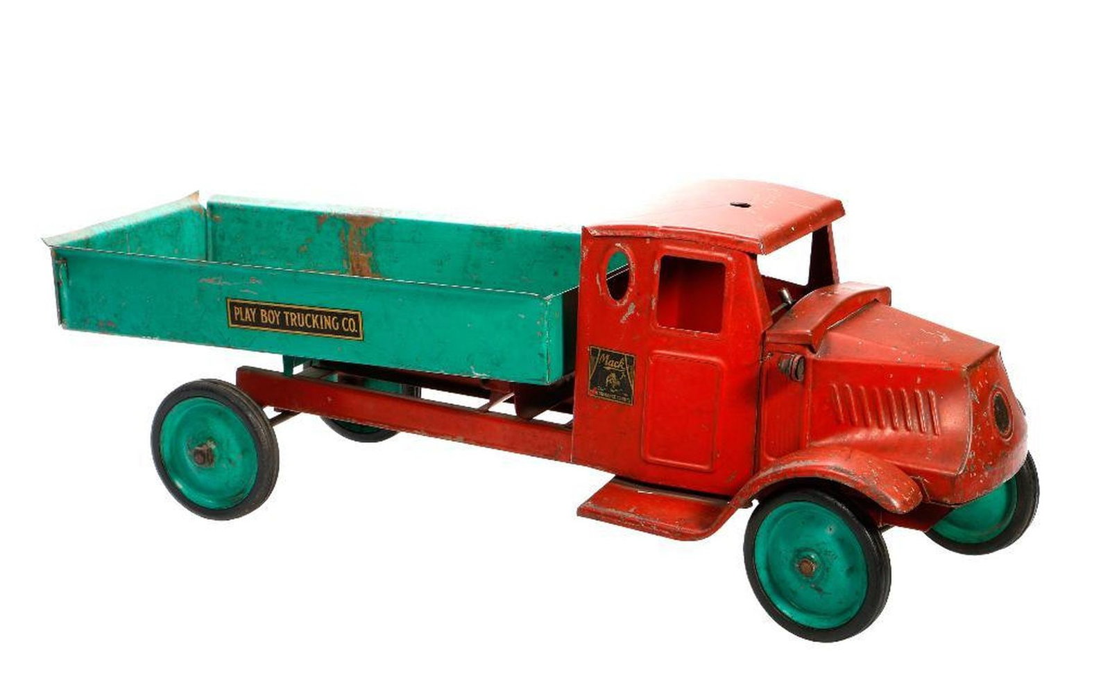 Steelcraft Mack Play Boy Trucking Co, Truck: The red cab with Mack decal; a green dump bed with a black Playboy Trucking Co. decal; and green wheels, 6.5"h x 24"l x 10"d Condition: Missing electric light and wood grip steering handle, some