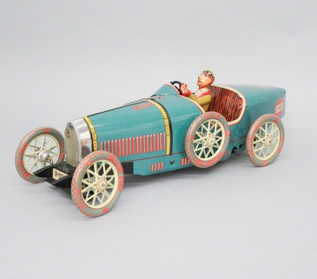 Paya S.C.V.L., Bugatti Race Car with Driver: A Bugatti clockwork race car with driver; turquoise body with red and yellow accents; black cat on side near front; maker's mark on side; key in small poly bag attached to steering wheel with red