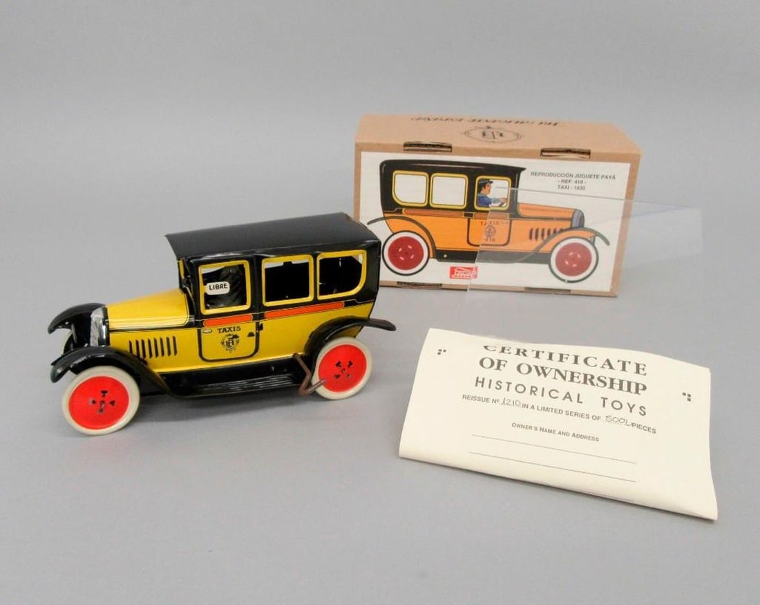 Paya S.C.V.L., taxi: Circa 1998. Tinplate toy taxi car with driver; yellow and black exterior; white wheels with red hub caps. Having original cardboard box with color illustration of taxi in profile on lid; a
