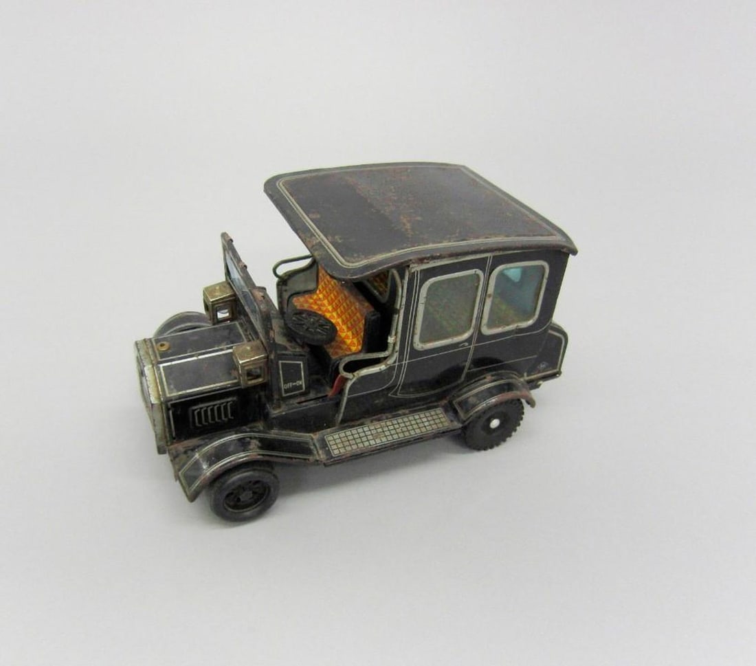 Vintage Black Car: Battery-operated black toy car; lithographed tinplate interior; hatch on underside of car for three 1.5V batteries (missing); On/Off switch by steering wheel. Dimensions: 5.5" x 5.5" x 9.5" C