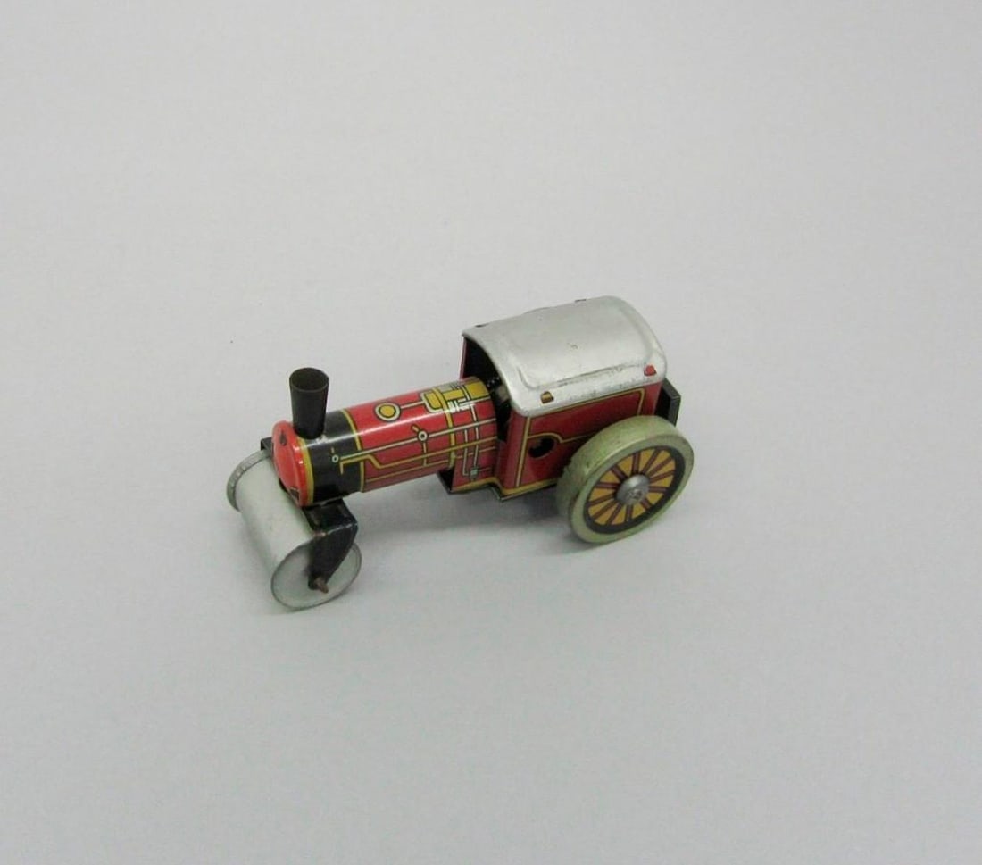 British Silver Tractor: Tinplate toy tractor with silver roof, roller front, and "Made in Great Britain" printed on side. Dimensions: 2" x 2" x 3.75" (5.1 x 5.1 x 9.5 cm). Condition: Rust on axle., front section