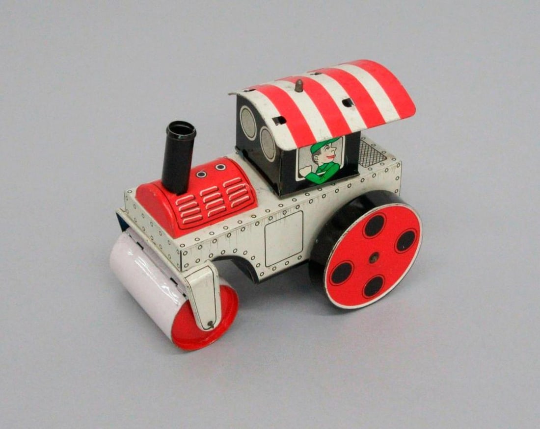 Japanese Tinplate Tractor: Patriotic red and white tinplate toy tractor with red wheels and roller in front. The tractor with stylized M logo and "Made in Japan" printed beneath. Dimensions: 4" x 2.75" x 4.25"