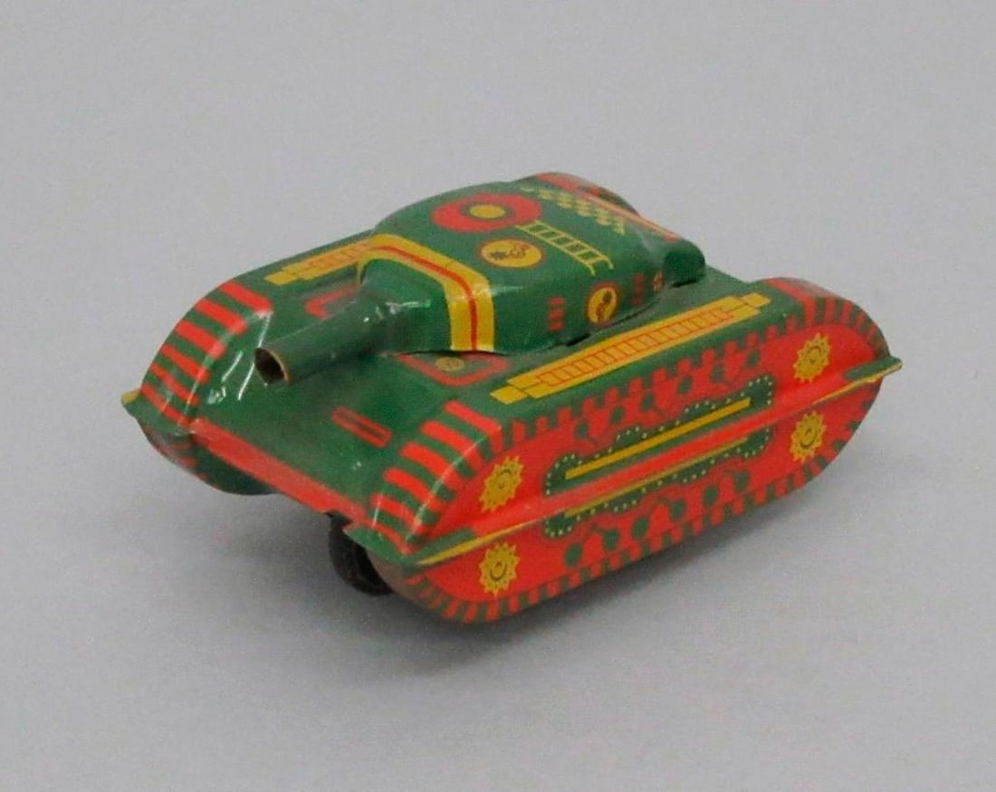 Tinplate Friction Tank: Green tinplate friction tank with rubber wheels and painted details. Dimensions: 1 3/4 x 2 x 3 inches (4.4 x 5.1 x 7.6 cm). {Minor scratches throughout} SFO Museum Deaccessioning Project SFO Museum