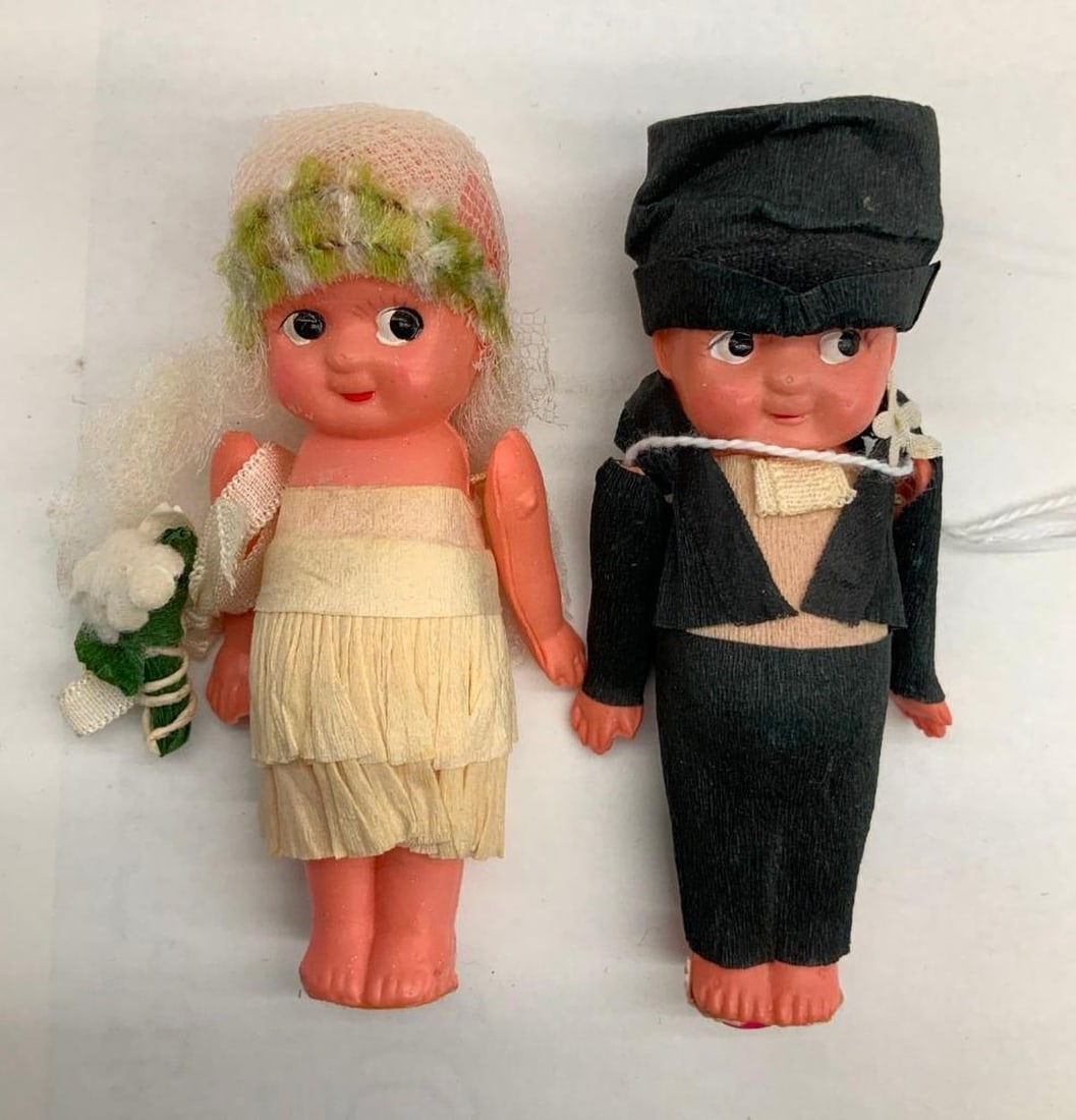 Kewpie Bride and Groom Cake Ornament: Circa: 1945, Medium: celluloid, paper, lace, Dimensions: 3.5" x 2" (8.9 x 5.1 cm) SFO Museum Deaccessioning Project SFO Museum is conducting a review and downsizing of our holdings that fall outside