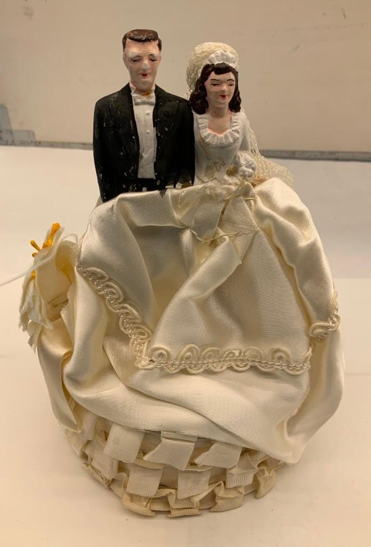 Cake Ornament of a Bride and Groom: Circa: 1955. Dimensions: 7" x 4.5" (17.8 x 11.4 cm) SFO Museum Deaccessioning Project SFO Museum is conducting a review and downsizing of our holdings that fall outside our collection focus. In the