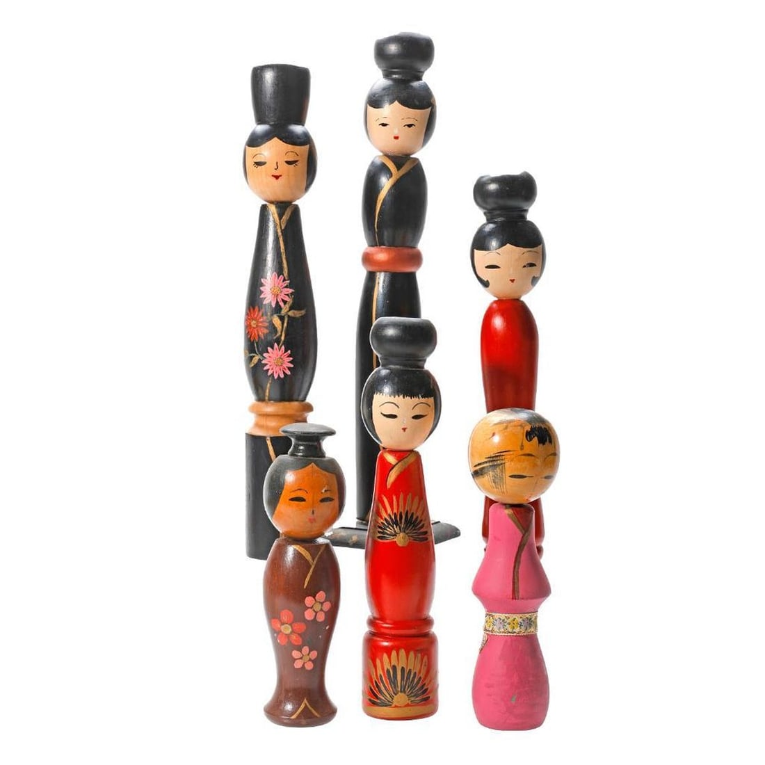 Nineteen Japanese Kokeshi Folk Art Dolls: Comprising six tall baluster shaped dolls, each allover painted in black, red, brown or pink, several with floral sprays and two with a ribbon lengths; a boxed Okinawan Miyarabi doll