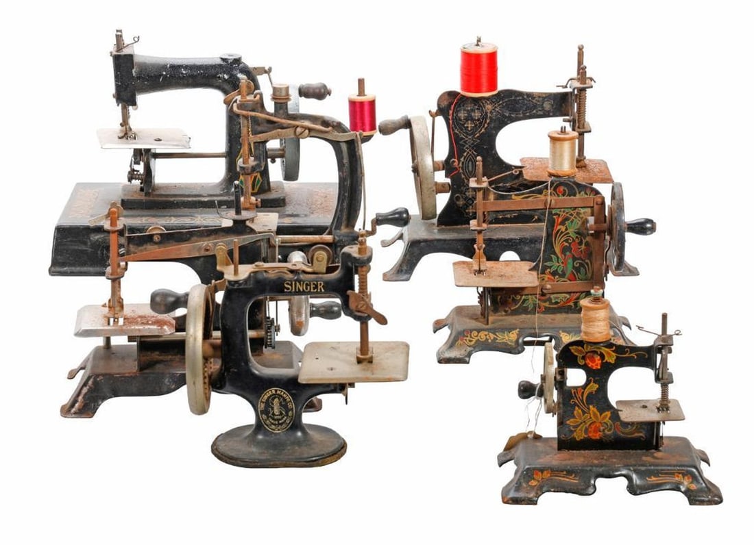 Seven Att Nouveau Miniature Sewing Machines: Including a Singer; a French JC/LP/Rw "Baby"; (2) German miniatures; the largest 8"h x 9.5"w x 5."d