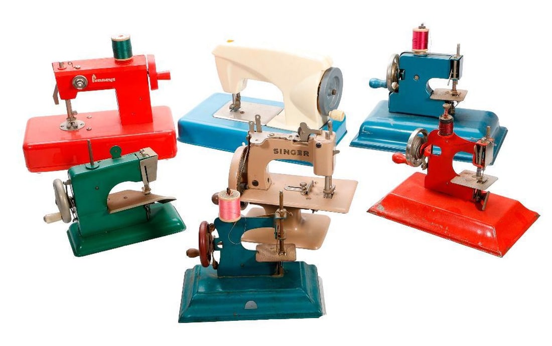 Seven Mid Century Miniature Multicolored Sewing Machines: Including a Singer tan model and a red Penney's model, the largest 6"h x 9"w x 5"d