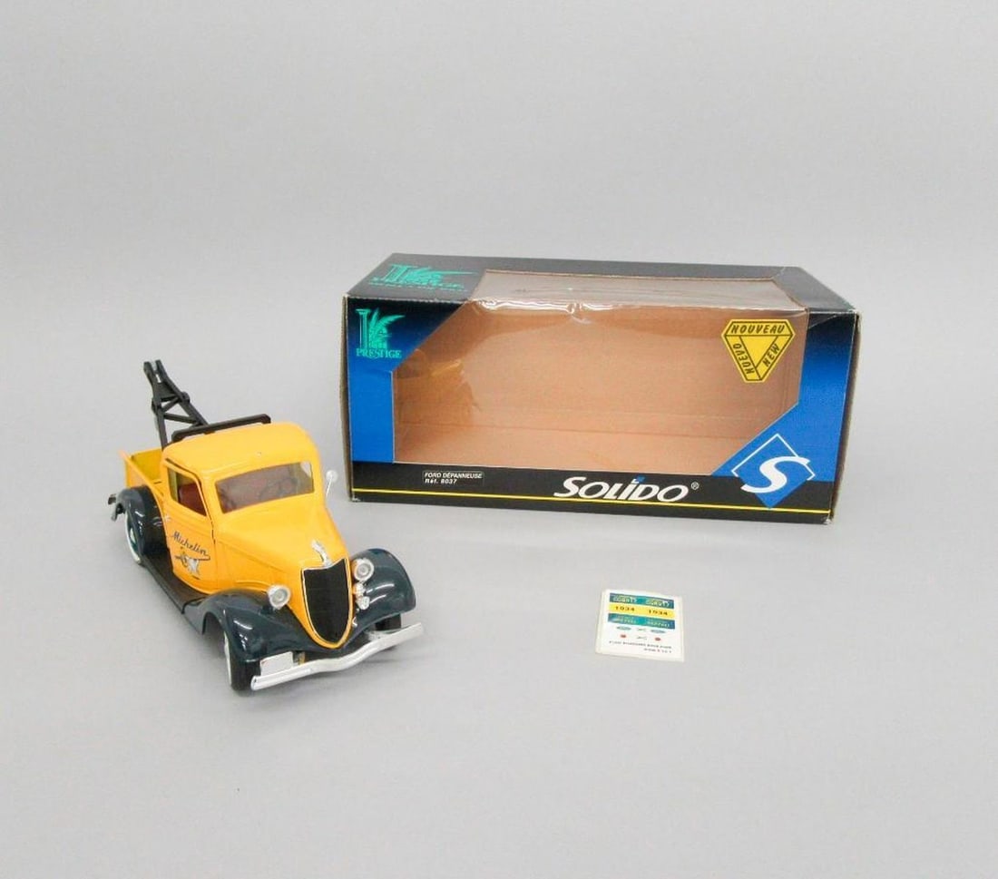 St. Nlle Solido Ford V8 D" panneuse tow truck: Circa 1998. Yellow and dark blue Ford V8 D panneuse die-cast tow truck with Michelin logo on doors, black boom and winch system, spare tire, original box, and decal sheet. Dimensions: 5.5" x 12.25" x