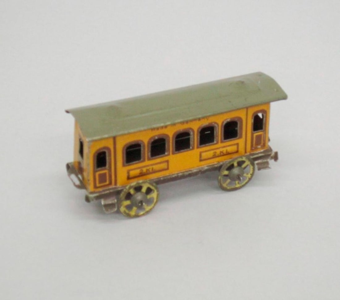 Huki Passenger Train Coach Car: Yellow toy coach car with green roof; '2 KL' printed on sides. Dimensions: 1 1/2 x 1 1/2 x 4 inches (4.4 x 3.8 x 10.2 cm). Condition: Slightly bent at back. Wheels are slightly distorted. Abrasions an
