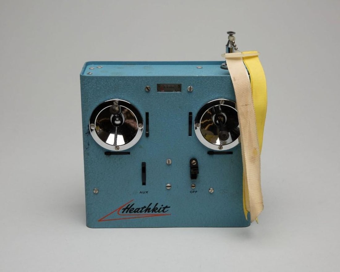 Heathkit Company, model airplane transmitter: Circ 1960s. Model airplane transmitter manufactured by Heathkit Company; turquoise with 2 joysticks and antennae, 4 manual switches on front panel, power plug on bottom; enamel-coated pressed metal.