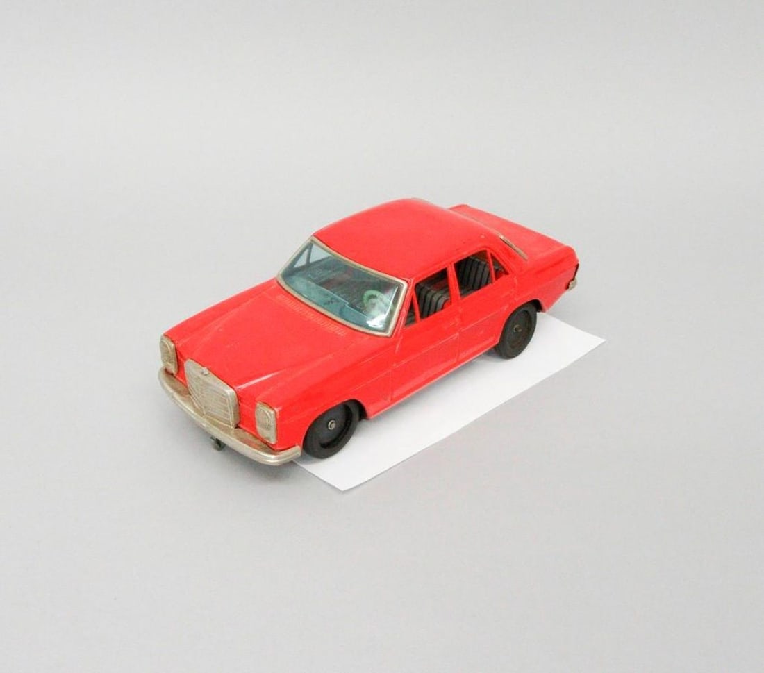 Taiyo Toys Mercedes car: Red toy Mercedes car with black wheels, plastic windshield; battery operated; battery compartment on underside near red on-off switch; Taiyo Toys manufacturer's mark and "Made in Japan" printed on