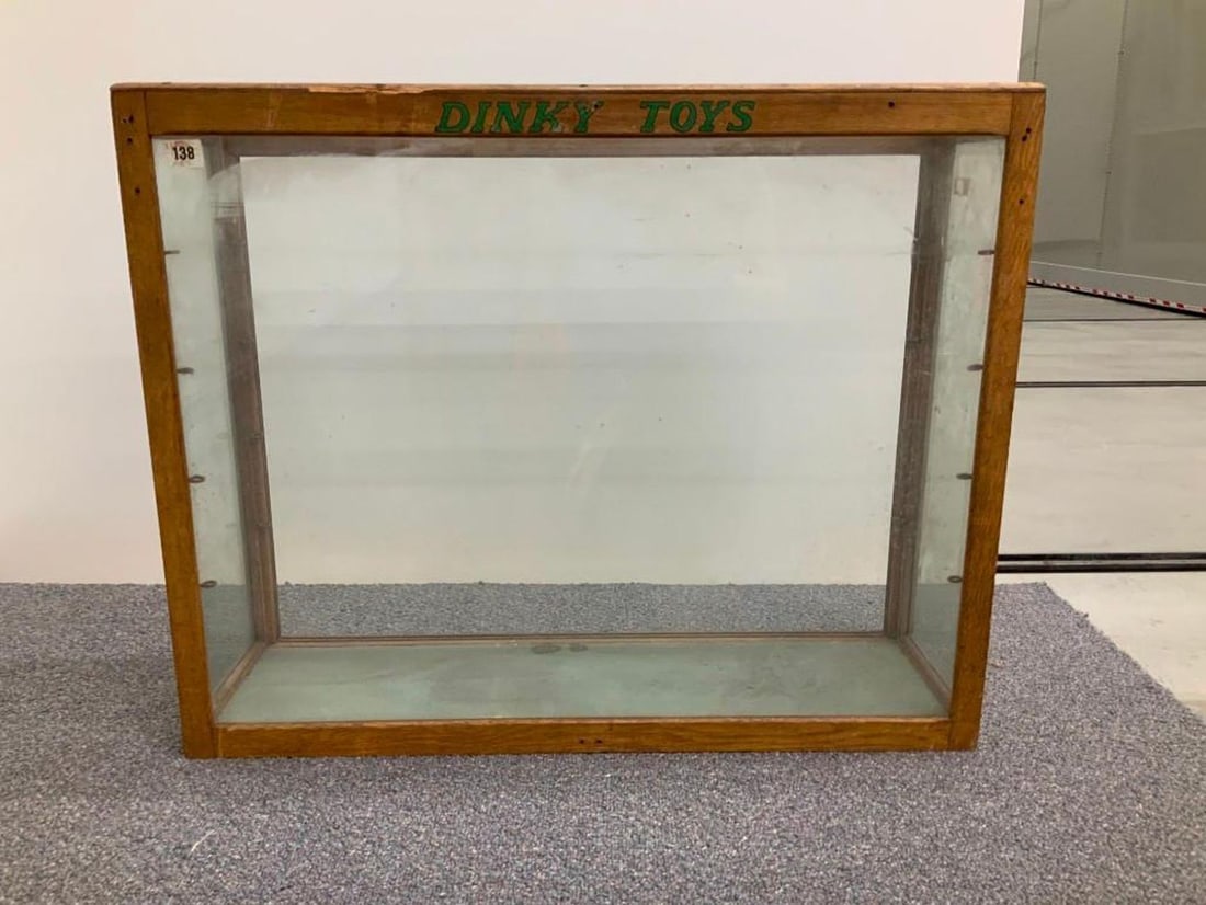Dinky Toys oak retailer's display cabinet: Circa Late 1950s. A glazed display cabinet having four glass shelves, two glass sliding rear doors and green and black Dinky Toys' logo. Dimensions: 24 x 30 x 9 inches. Condition: Missing screws and r