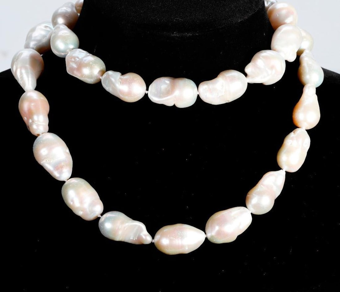 A freshwater cultured pearl and silver necklace: composed of 31 fireball freshwater cultured pearls, measuring from approximately 33.0 x 17.8 x 18.8mm to 23.6 x 15.4 x 15.4mm, completed by a butterfly motif clasp accented by rhinestones; length: 30 