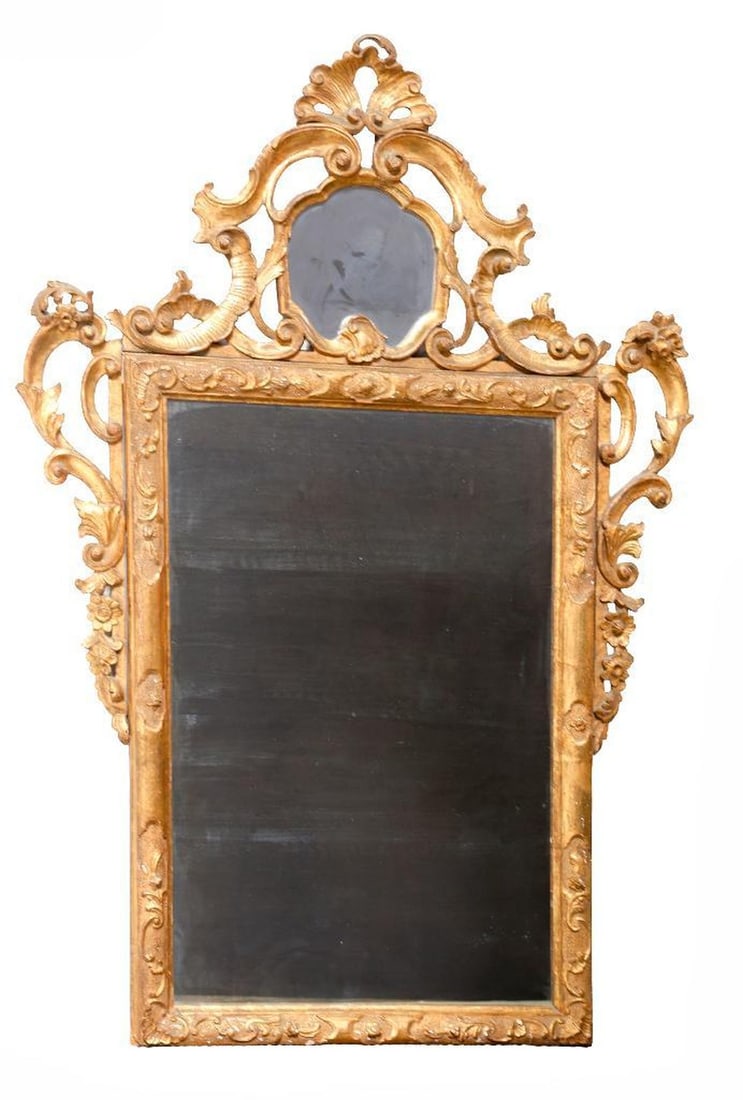 Italian Rococo Style Giltwood Mirror: The looking glass or mirror plate headed by shell and cartouche shaped mirrored crest, the sides decorated with applied auricular gilt scroll ornaments. Size approximately 58"h x 40"w Condition: Overa