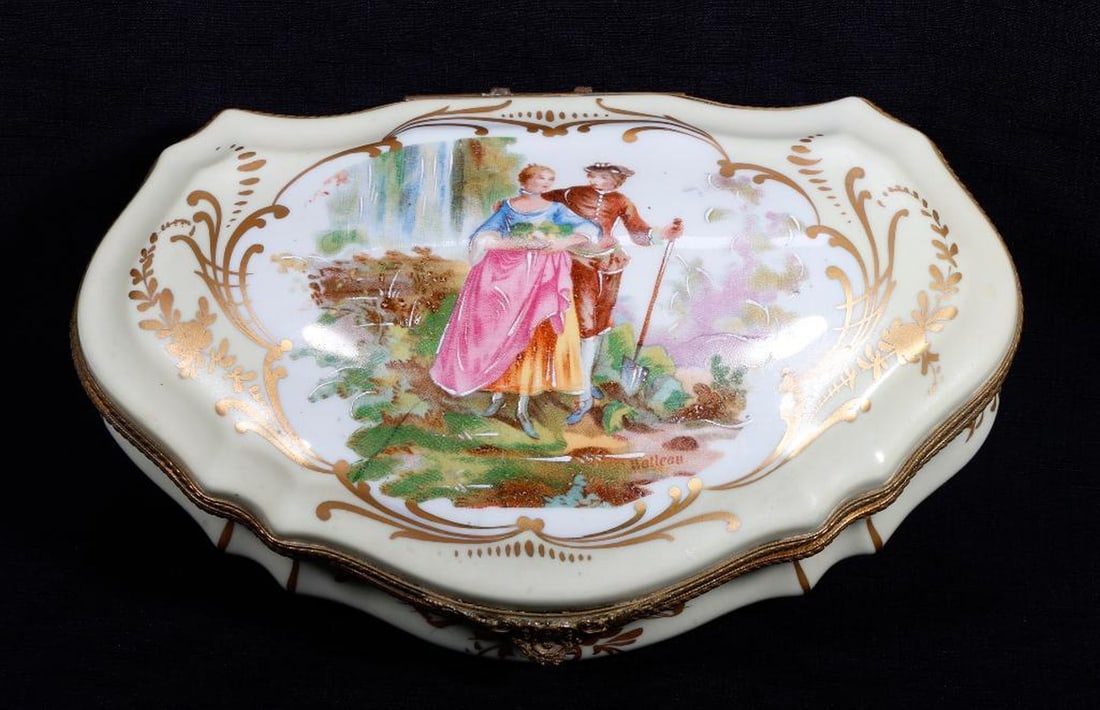 Sevres Style Limoges Gilt Metal Mounted Porcelain Casket: The bombe lid centering with a courting couple, the whole reserved on a pale ivory ground, the base with gilt stenciled floral decorated, the base stamped "HAND PAINTED/MADE IN FRANCE" 4'h x 11"w x 7"