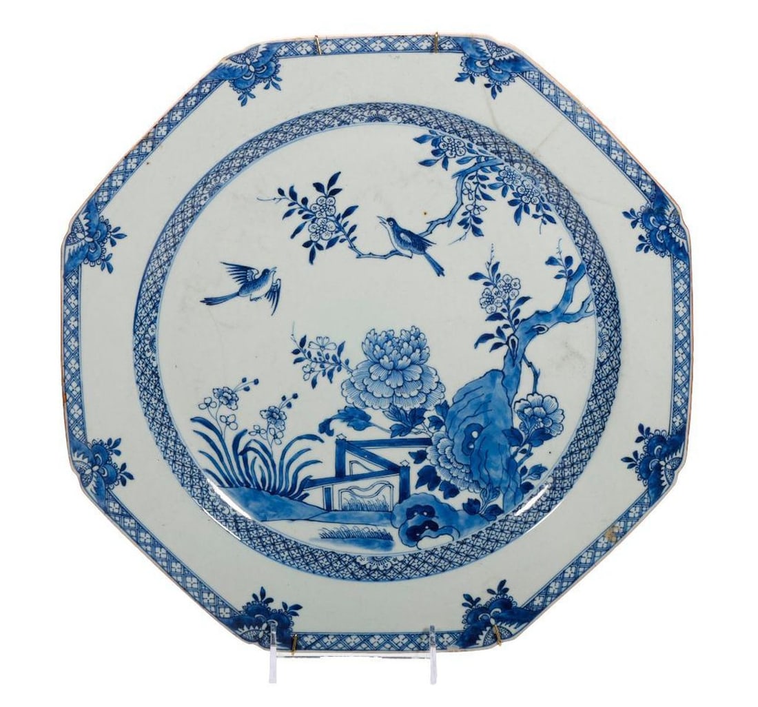Two Chinese Imari Chargers: The larger, an octagonal shaped dish decorated in undrglaze blue with large flowering flowers, perching birds, a rock and a fence; the smaller, a round plate with a shallow well decorated in unde