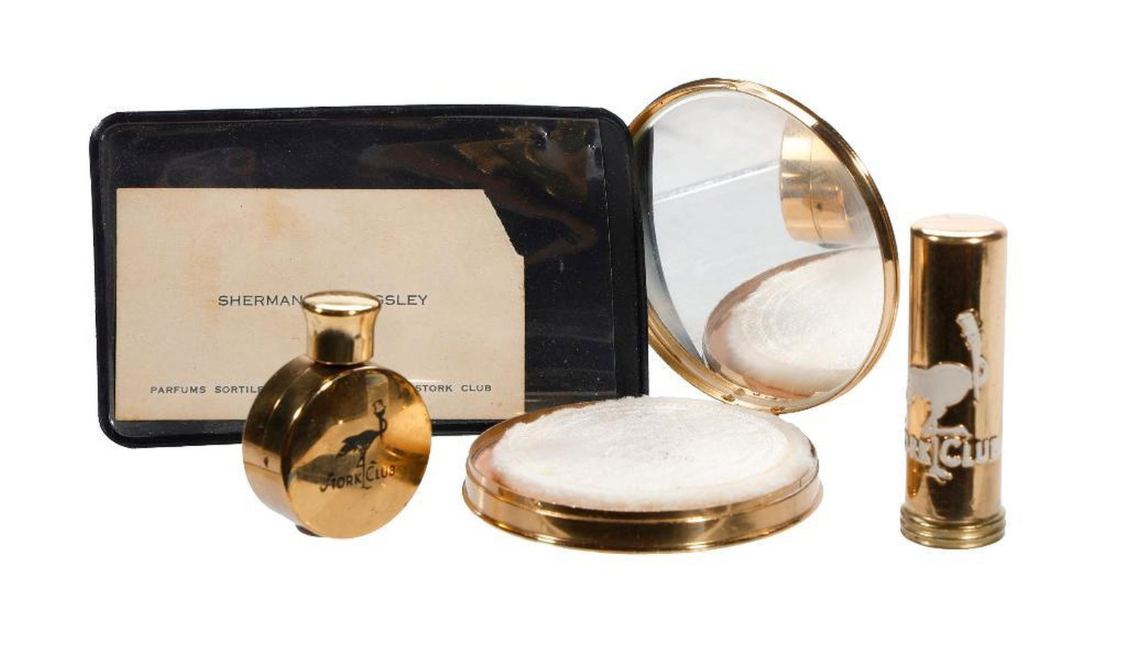 The Stork Club Compact, Lipstick, Perfume, and Billingsley Card: A collection of vintage Stork Club gifts from owner Sherman Billingsley's range of gifts and souvenirs, comprising brass/gold-toned cosmetics "Dist. by Cigogne, Inc. New York, NY", including a co