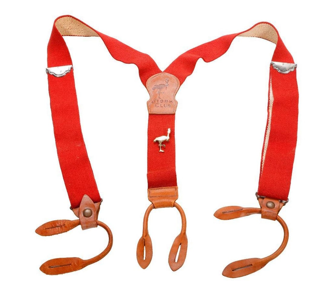 The Stork Club Vintage Suspenders and Lapel Pin: A pair of red band and brown leather Y-back suspenders, the leather crosspatch embossed with "Stork Club" and logo. Condition: overall good, with moderate wear to leather; light wear/soiling to bands.
