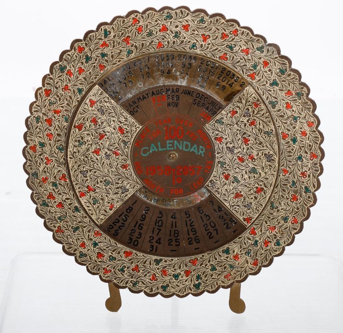1958-2057 Brass Calendar, with Greyhound Desk Ornament: A vintage desk calendar that's still in play: Calendar For 100 Years, 1958 to 2057. The wheel-form calendar of sheet brass design with painted floral decoration, title, and dates, and easel stand. 8 1