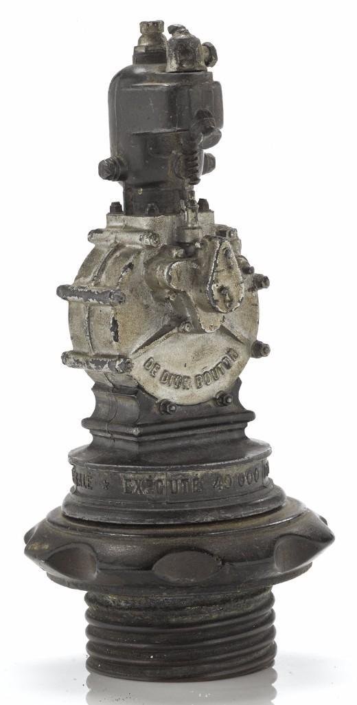 DE DION BOUTON ENGINE PAPERWEIGHT: Height: 6 1/4 inches Sy and Ronnie Margolis's eclectic collection features a wide range of hood or fender ornaments, from about 1909 to recent times. Most date from the 1920s and 1930s, with many from