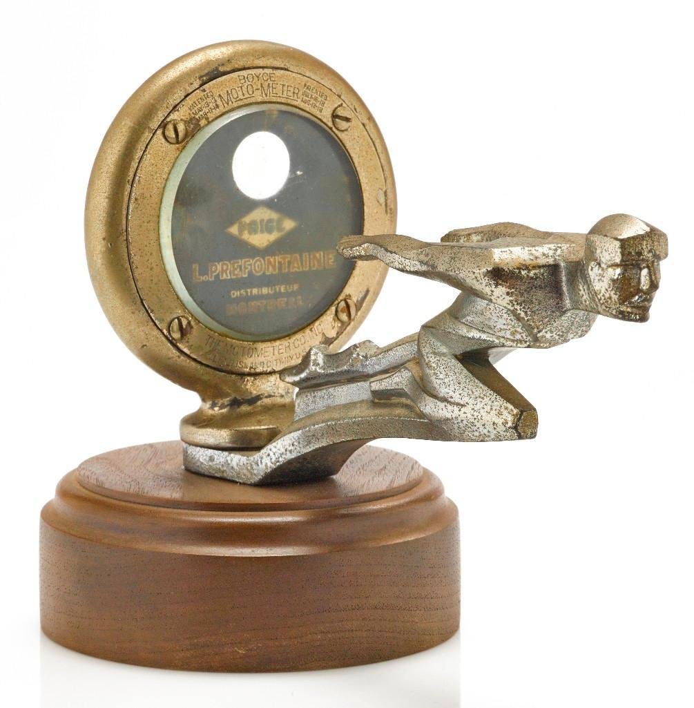 STYLIZED MAN ON PAIGE MOTO METER FACE MASCOT: Length: 7 inches Sy and Ronnie Margolis's eclectic collection features a wide range of hood or fender ornaments, from about 1909 to recent times. Most date from the 1920s and 1930s, with many from the