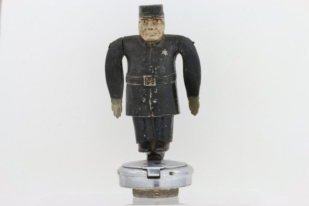 SAFETY FIRST POLICEMAN MASCOT WITH SPINNING ARMS: Height: 8 1/2 inches Sy and Ronnie Margolis's eclectic collection features a wide range of hood or fender ornaments, from about 1909 to recent times. Most date from the 1920s and 1930s, with many from