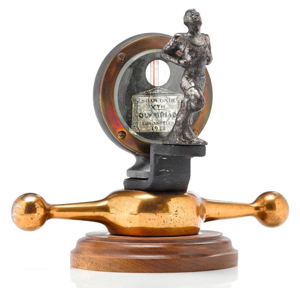 1932 L.A. OLYMPIC MOTO-METER WITH RUNNER MASCOT: Height: 6 inches Length across: 7 inches Note: The sale features 110 lots related to the 1932 Olympics in Los Angeles, including car mascots, radiator badges, license plates, banners, maps, pennants,