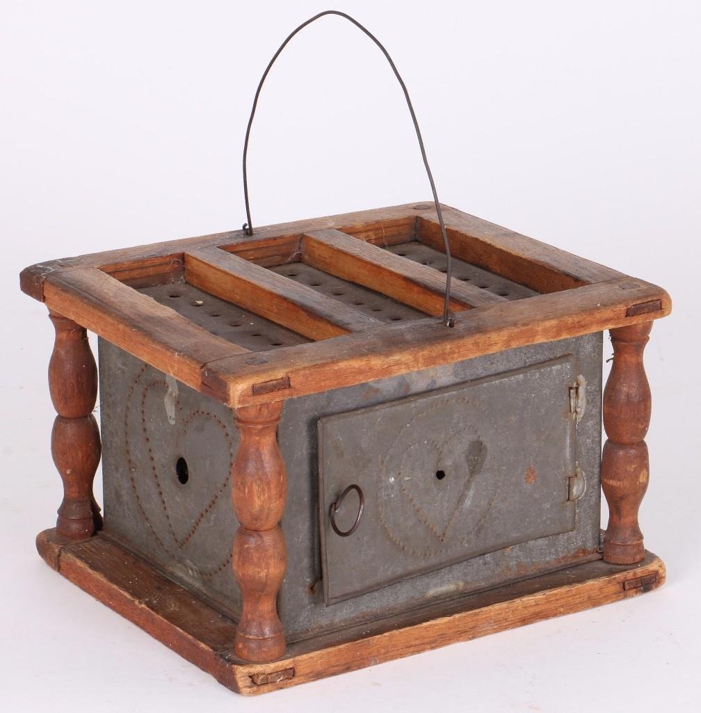 PUNCHED TIN & TURNED WOOD FOOT WARMER: 19TH CENTURY, HEIGHT 5 3/4 INCHES, WIDTH 9 INCHES, DEPTH 7 3/4 INCHES. Turner Auctions + Appraisals is pleased to present the Americana Collection of the late Alice S. Reynolds. Offering 180 lots, the