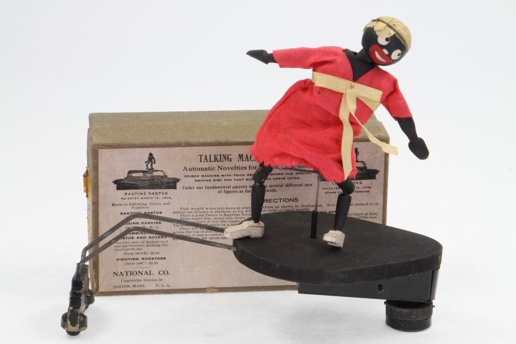 Ragtime Rastus Toy with Labeled Box: National Co, Boston, 1915; Dancing Female Figure on Platform that Rides on Record Disc "For the Edison Machine"; Wood/Wire Figure, Original Fabric Clothing, Diecast Wheeled Runner Supported 