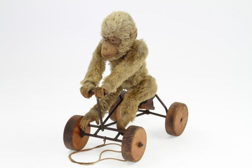 Monkey on Cart Pull Toy: Felt Figure, Wire/Wood Vehicle with Strings; Good Condition, 9 1/4"H x 9 1/8"L Notes:Turner Auctions + Appraisals is pleased to feature the Anita & Sedwick Hellman Toy Collection. Offering o