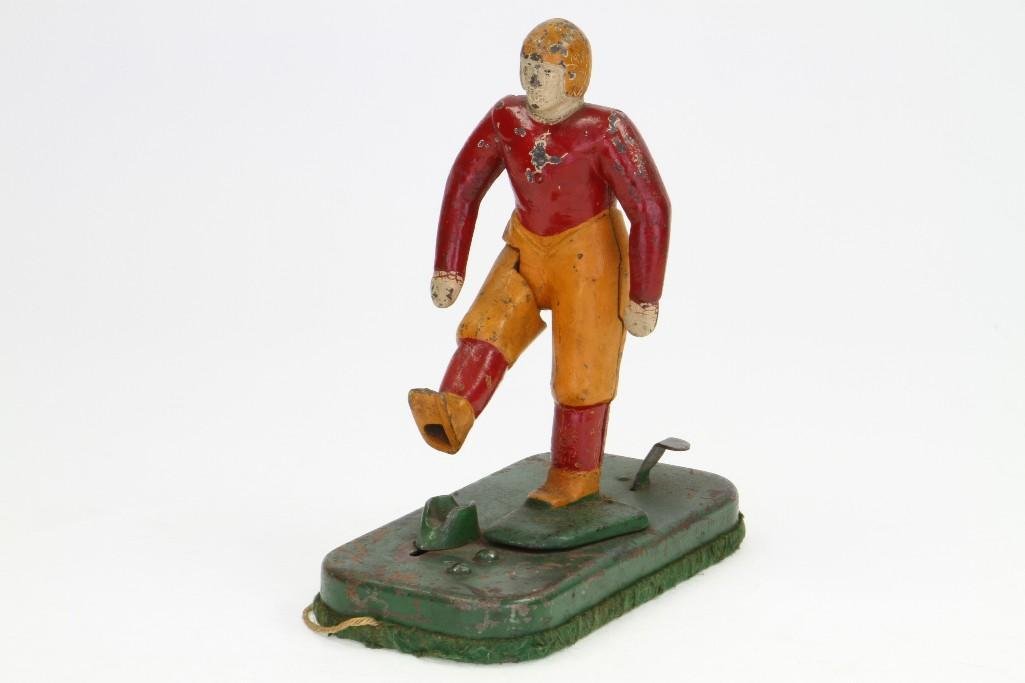 Cast Iron Football Player: Painted Figure and Base, Missing Football, Trigger Activated; Good Condition, 8"H Notes:Turner Auctions + Appraisals is pleased to feature the Anita & Sedwick Hellman Toy Collection. Offering ove