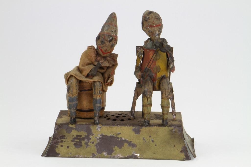 Seated Musician Figures: Gunthermann; Hand Painted Tin, Paint Loss, Clockwork Activated, Fair Condition, 4"D x 9"L x 9"H Notes:Turner Auctions + Appraisals is pleased to feature the Anita & Sedwick Hellman