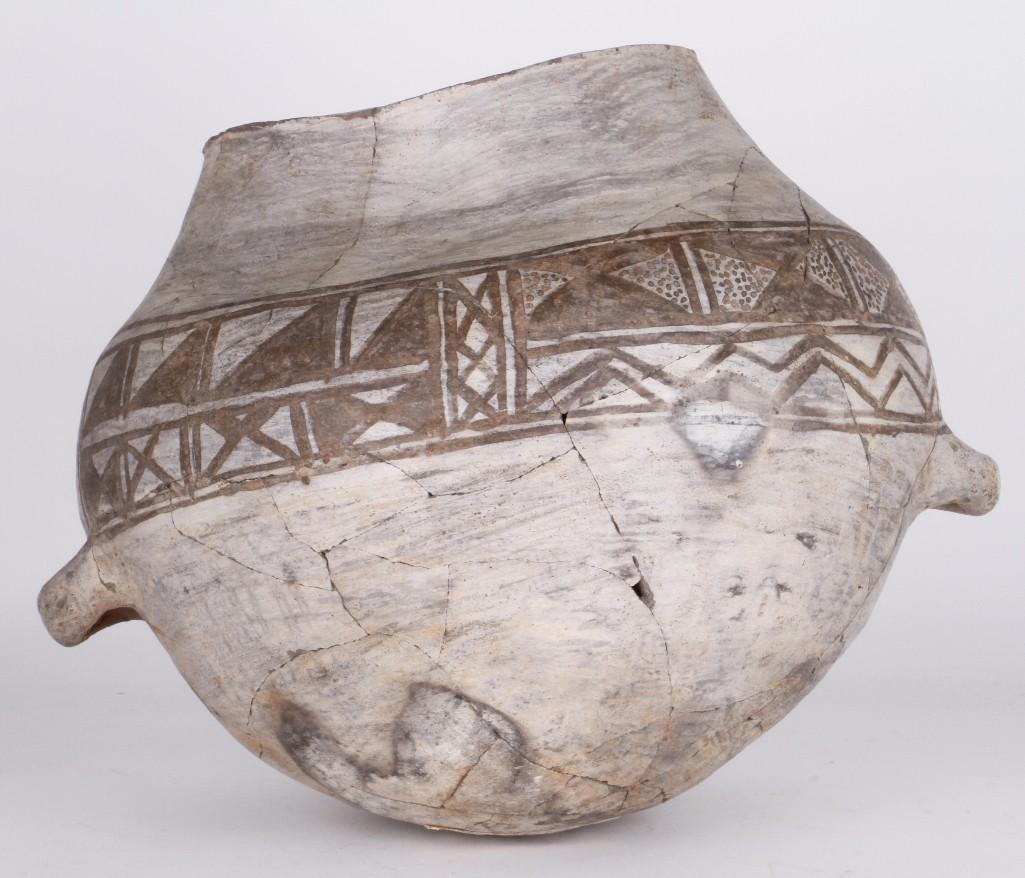 Anasazi black-on-white olla: Possibly Jemez, a separate design panel on each side, alternating with lug handles, minor restoration Height: 13 inches Maximum diameter: 16 1/2 inches Provenance: Turner Auctions + Appraisals is plea