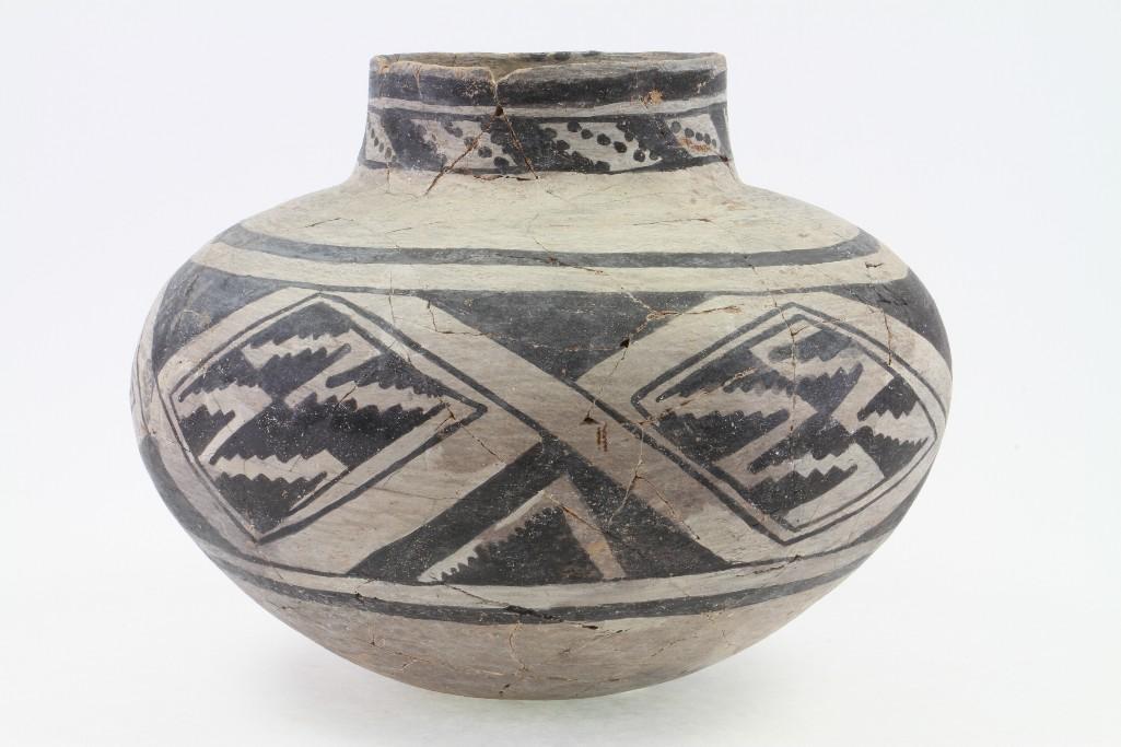 Anasazi black-on-white olla: Minor restoration: tape applied to stabilize the jar - in need of repair/restoration Height: 10 1/2 inches Width: 13 inches Provenance: Turner Auctions + Appraisals is pleased to offer the library and