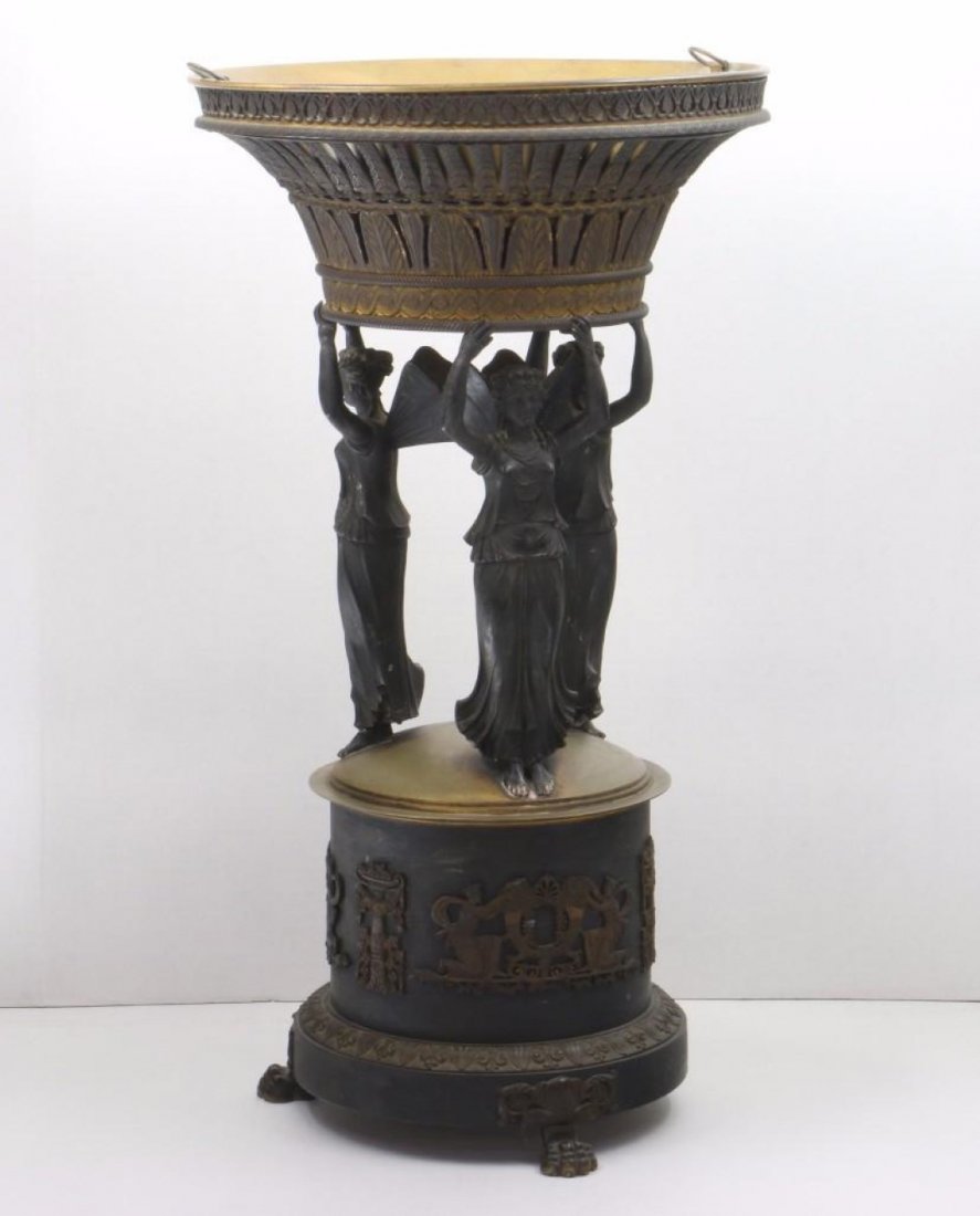 An Empire Style Bronze Figural Centerpiece 19th Century: Supported by three winged Nike figures. Height 24 inches. In original as found condition, gilding now worn and heavily tarnished, some traced of old metal polish residue in crevices.